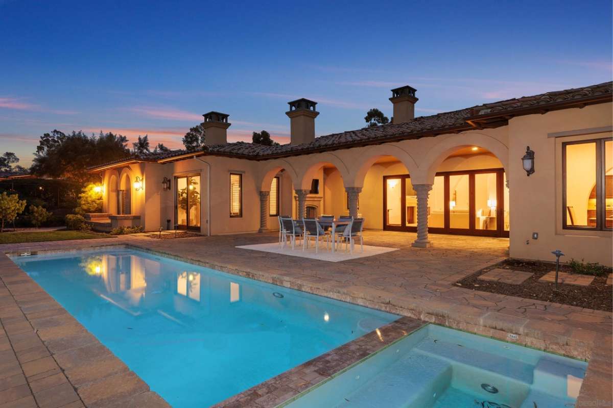 A swimming pool and jacuzzi with a brick poolside.