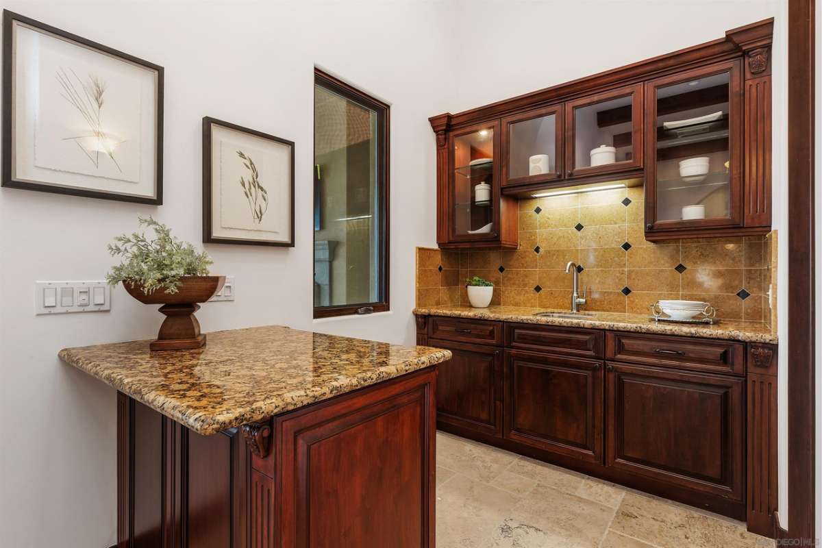 A kitchen with a countertop, sink, and wooden cabinets.