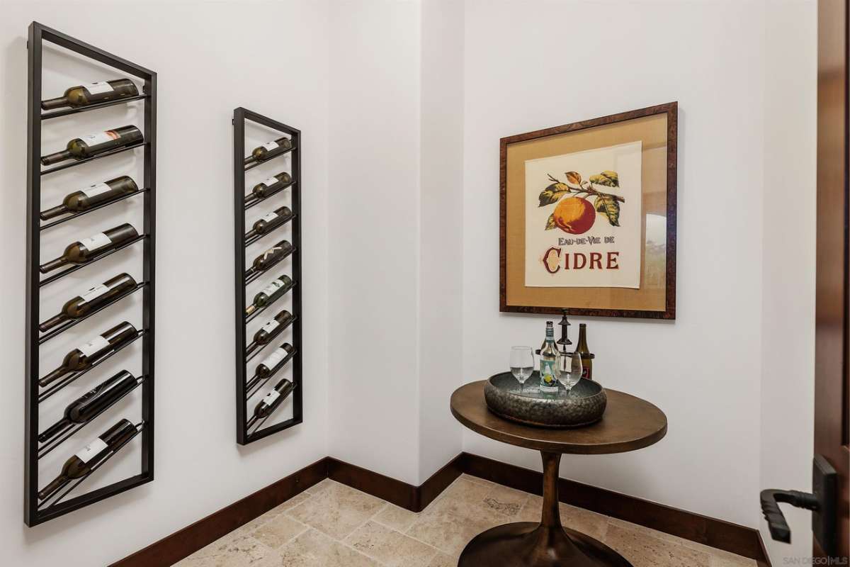 A wine room with a table and a wine rack filled with wine bottles.