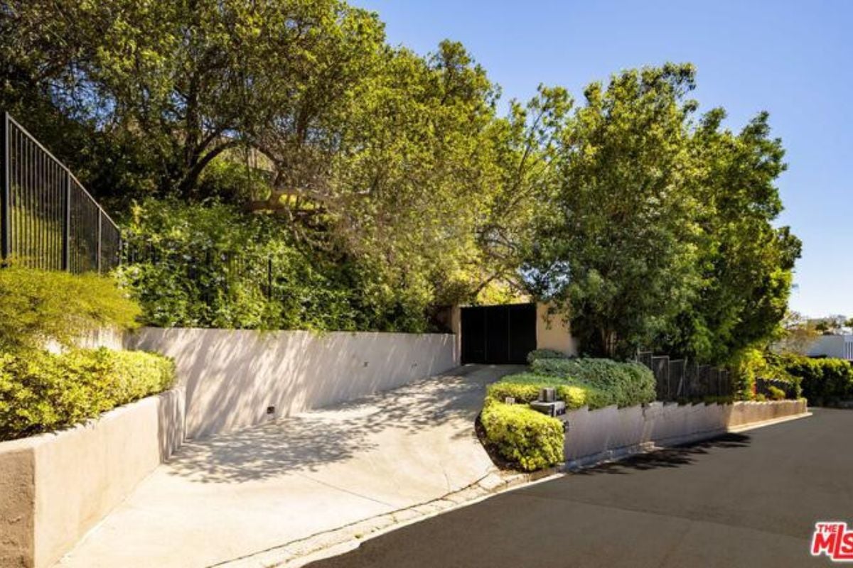 A front gate entry surrounded by trees.