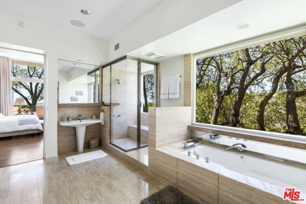 A bathroom with windows, a vanity, a mirror, a shower room, and a bathtub.