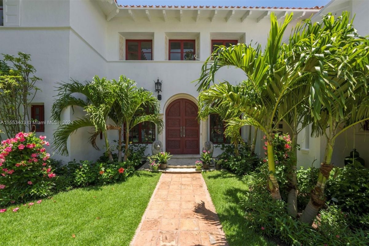 A front entry adorned with plants and trees.