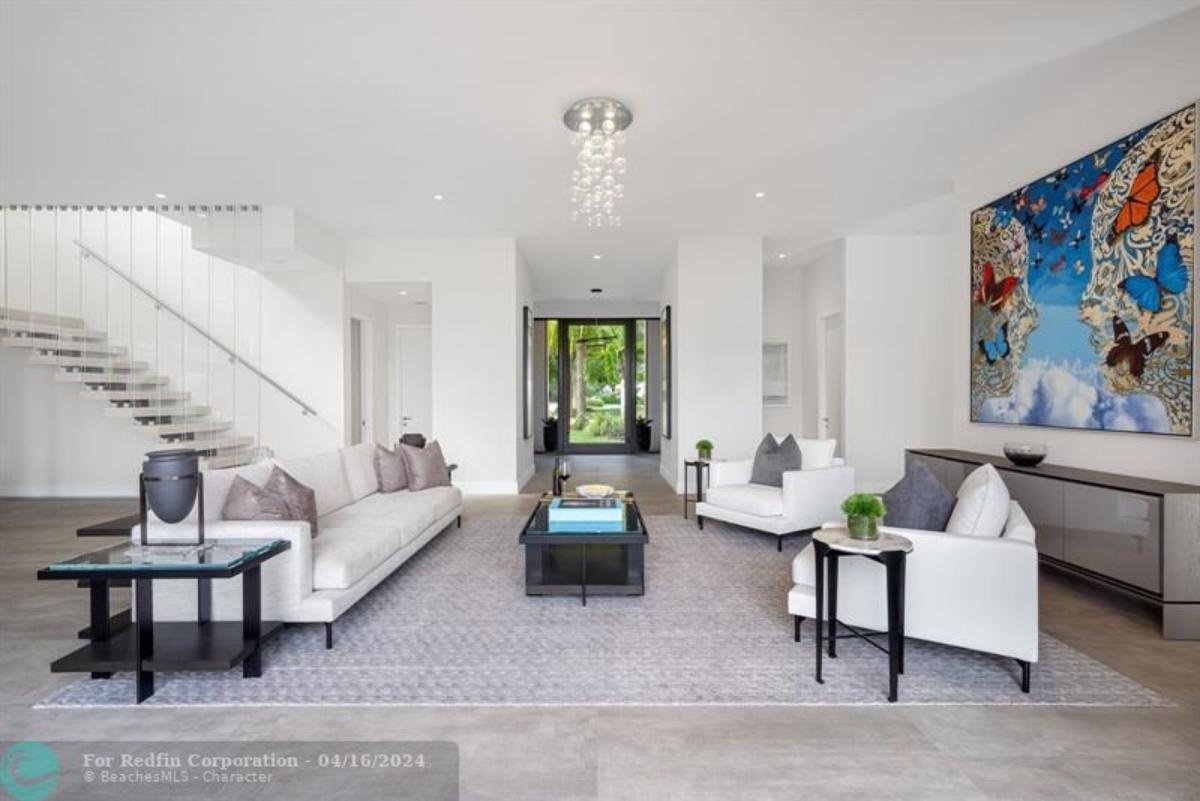 Living room with a chandelier, tables and chairs.