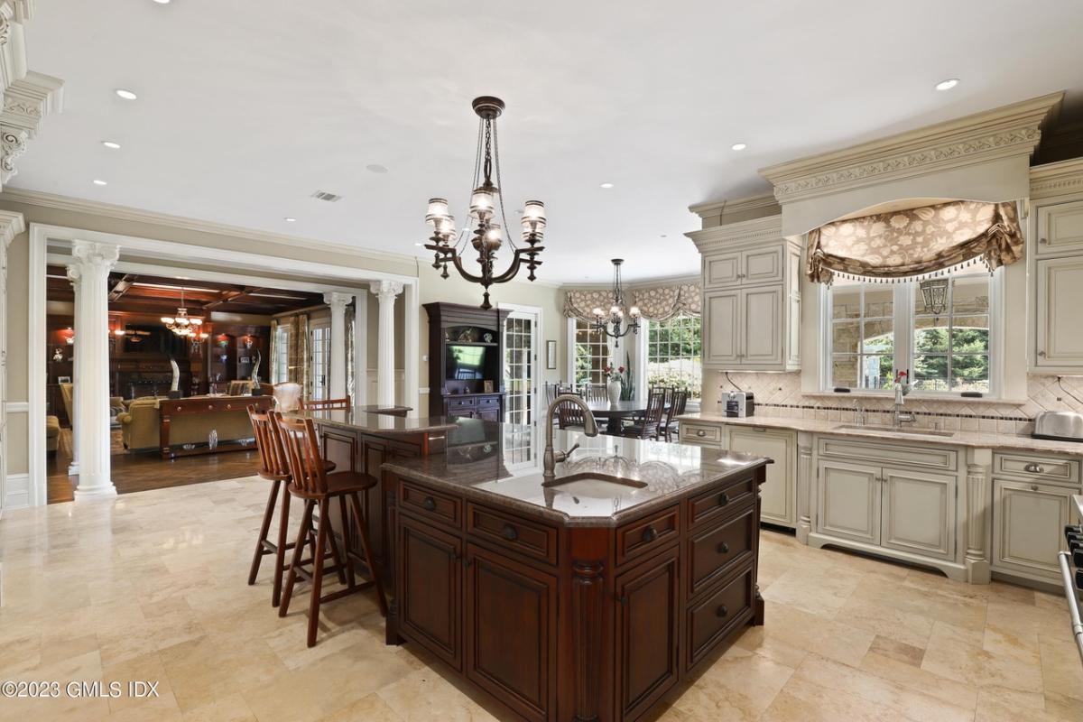 Kitchen with a large island, tile flooring and custom cabinetry.