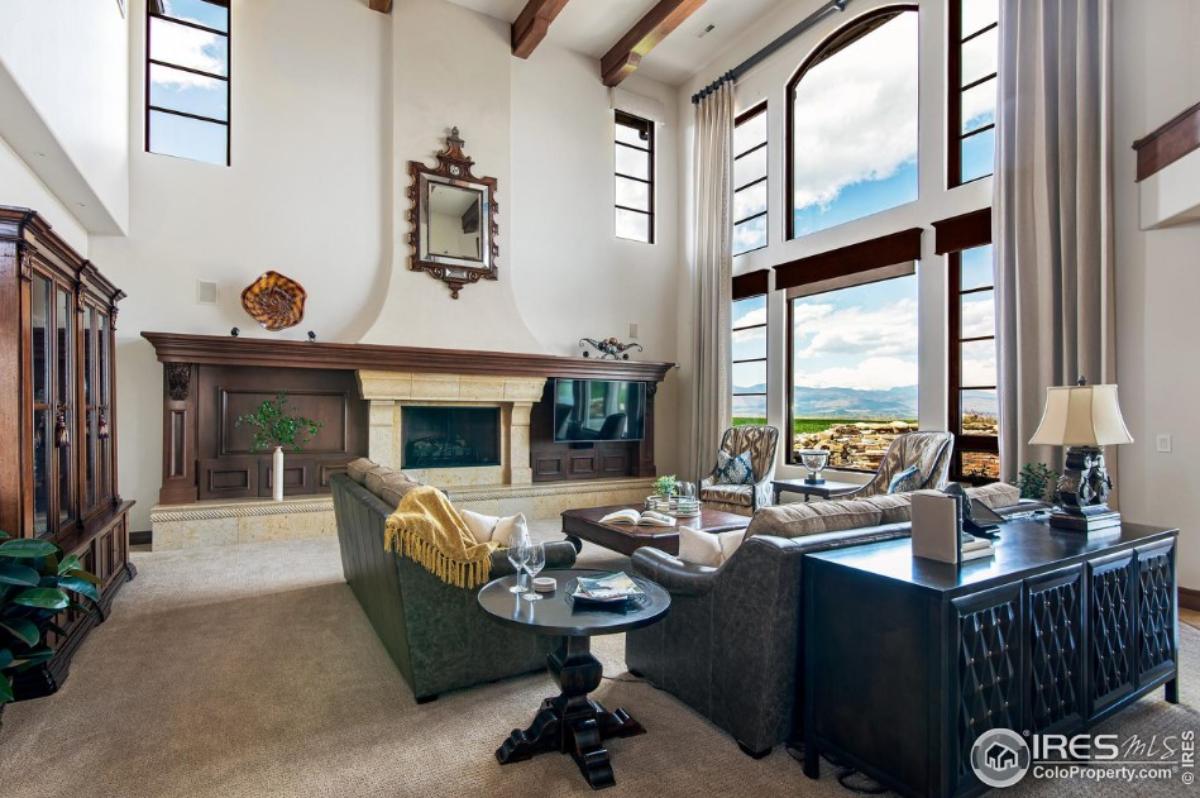 Living room with tables, chairs, couches and large glass windows.