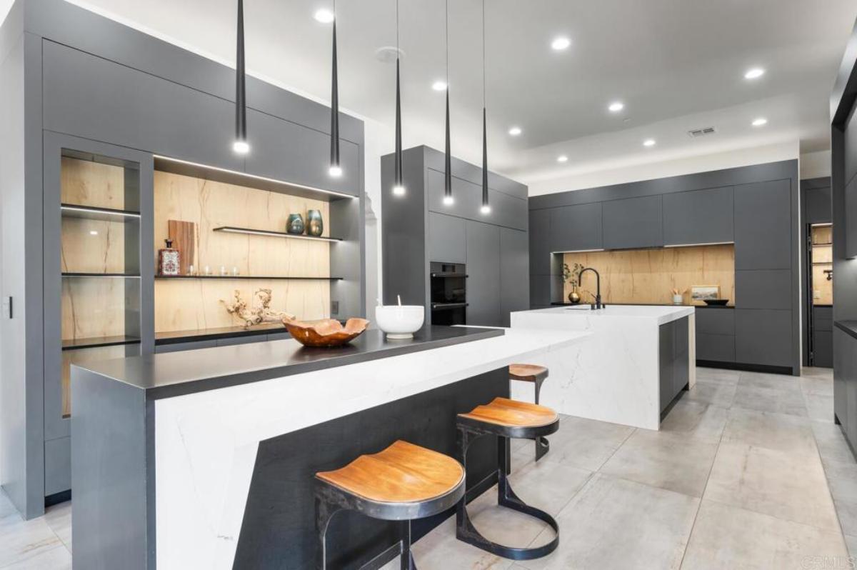Kitchen with large islands, custom lighting and custom cabinetry.