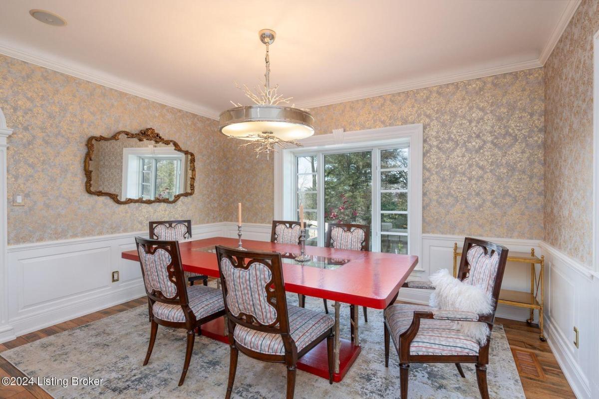 Dining room with a large table, chairs and glass doors.