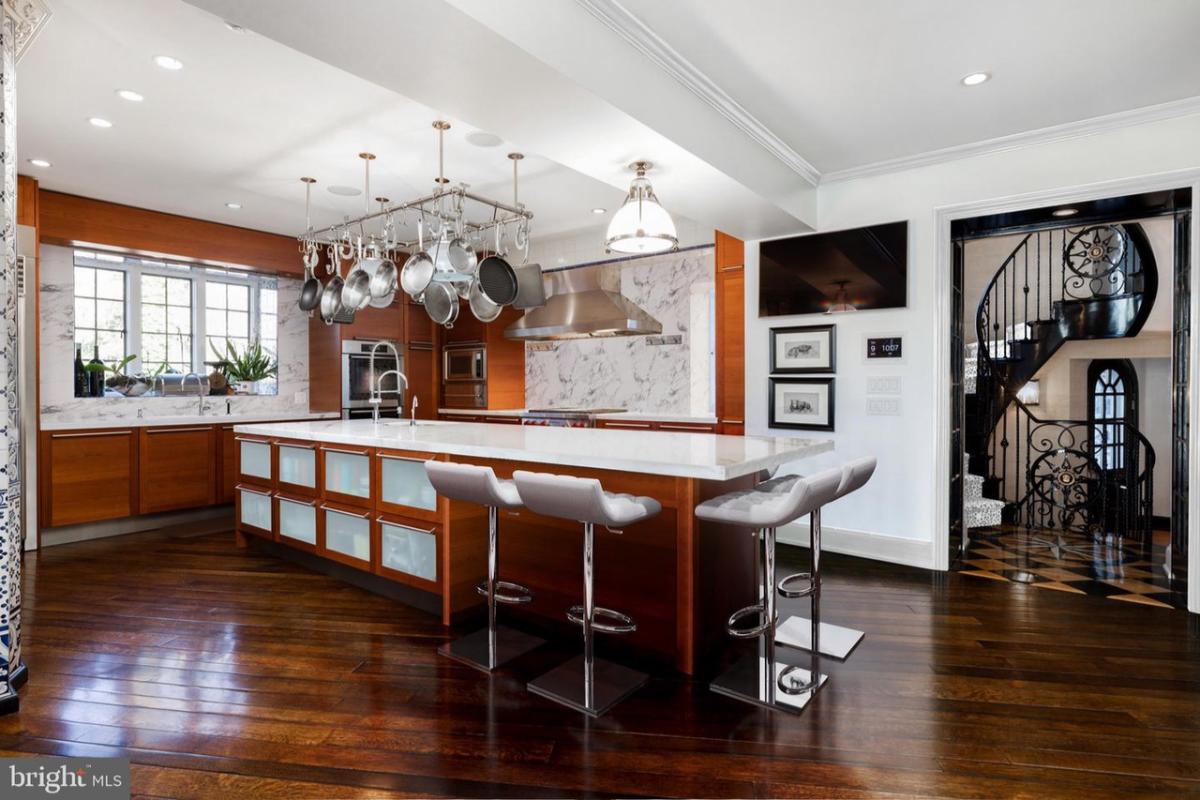 Kitchen with wood flooring, a large island and custom cabinetry.