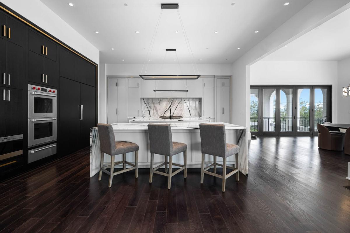 Kitchen with a large island, custom lighting and custom cabinetry.