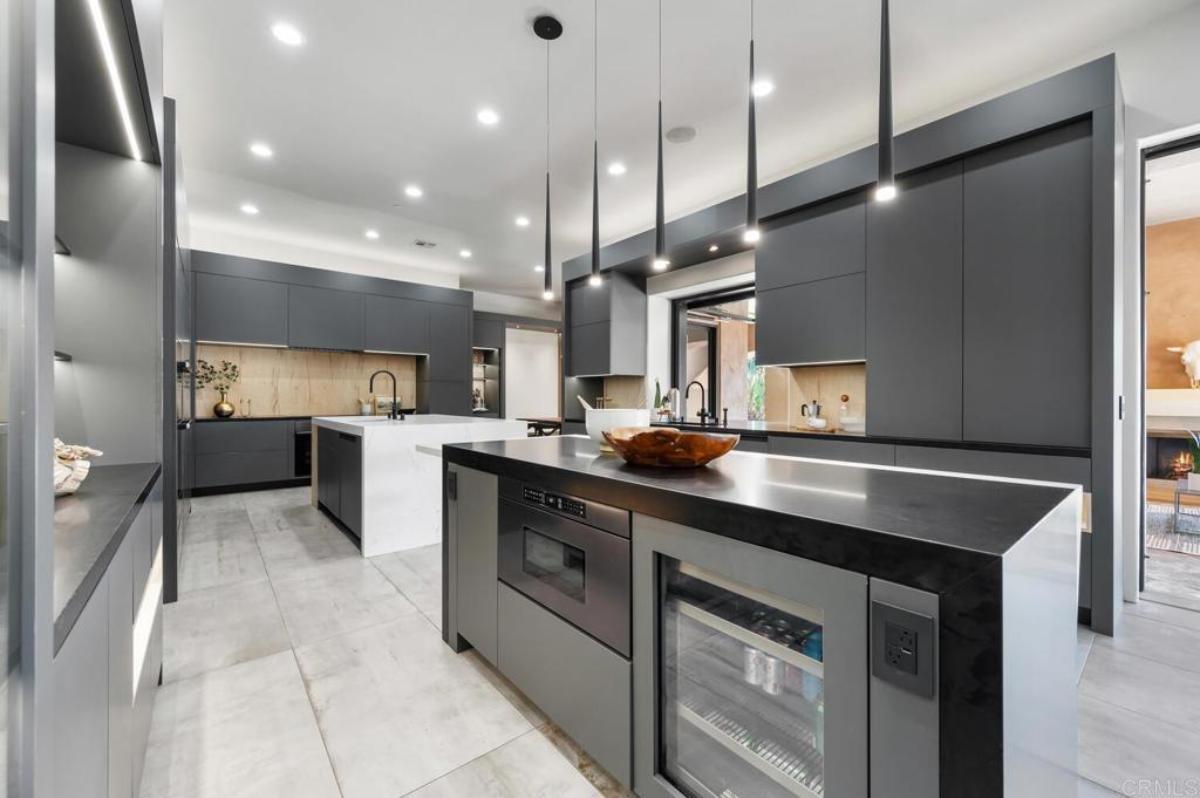 Kitchen with large islands, custom lighting and custom cabinetry.