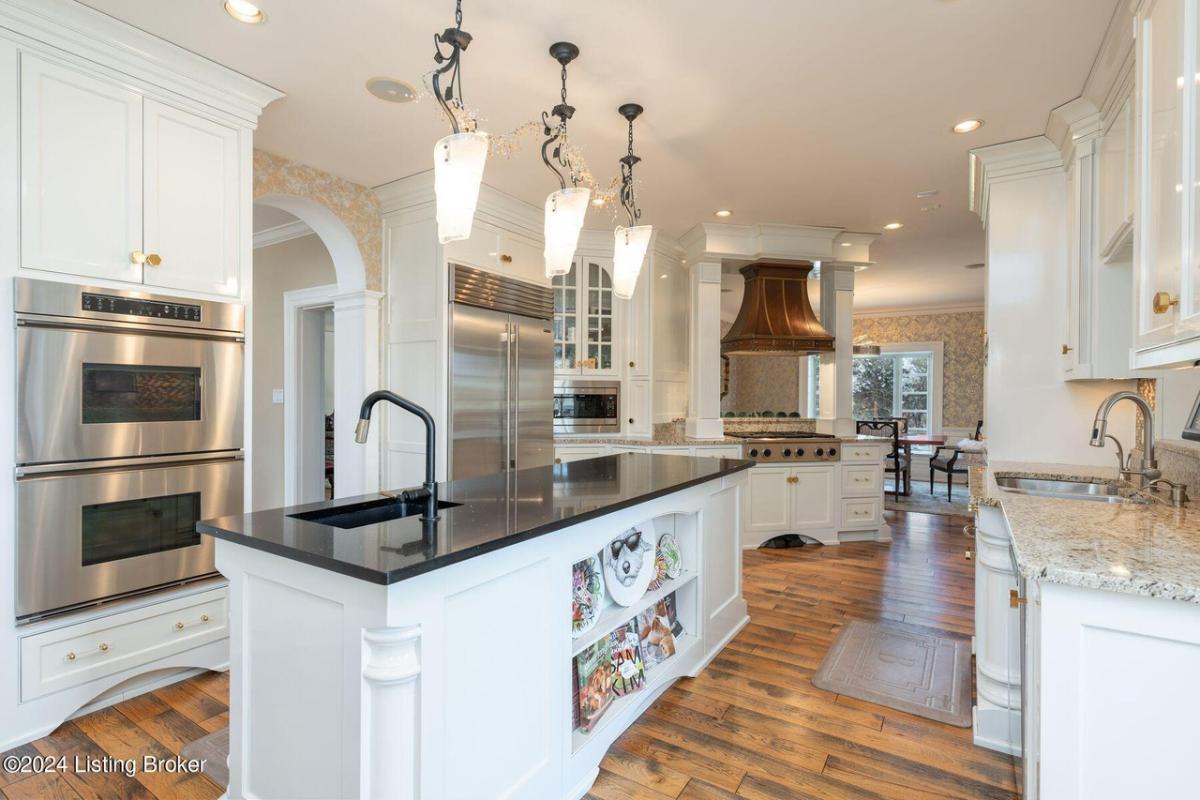 Kitchen with stainless-steel appliances, hardwood floors and custom cabinetry.