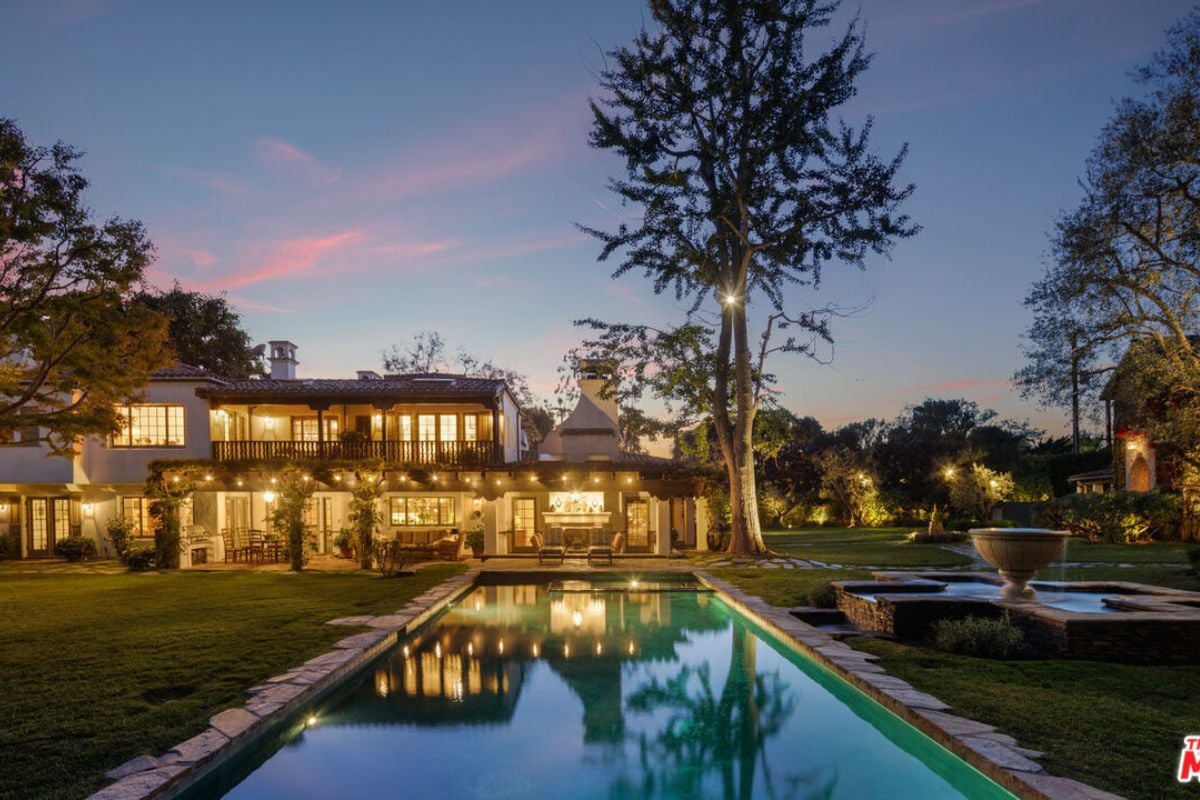 A swimming pool surrounded by grass and trees.