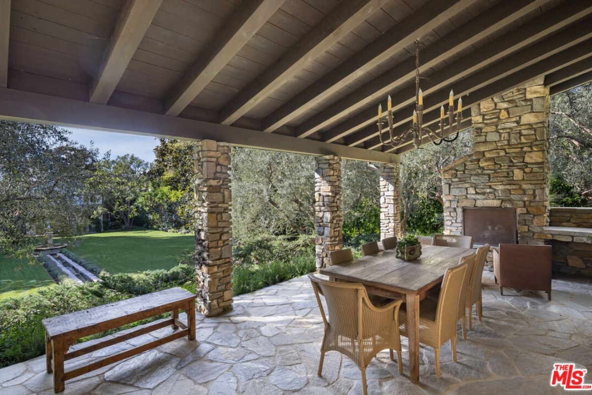 A patio with a bench, table, and chairs.