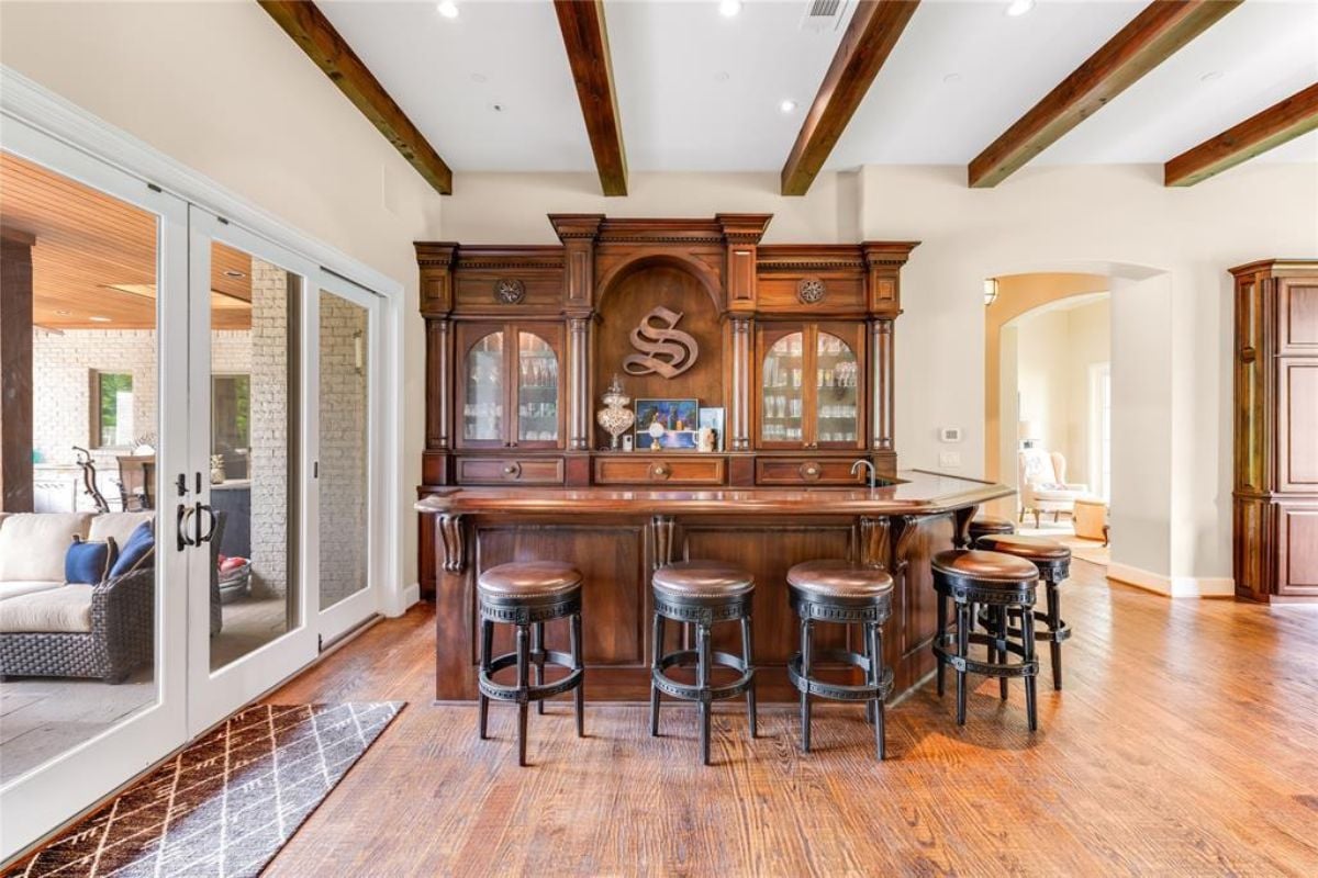A bar with a vaulted ceiling, countertop, and stools.