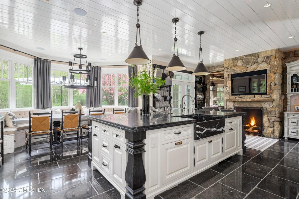 Kitchen with a large island, TV and a fireplace.