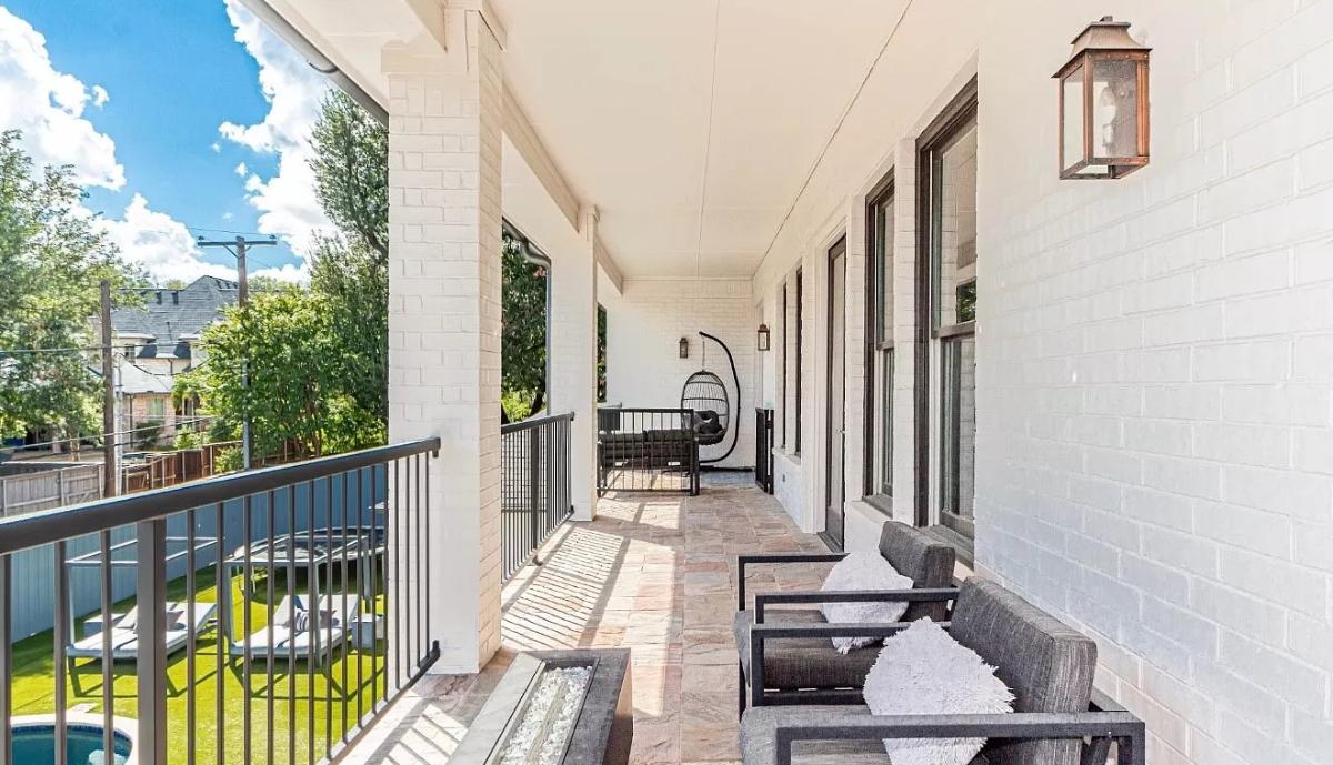 Balcony with chairs and metal railings.