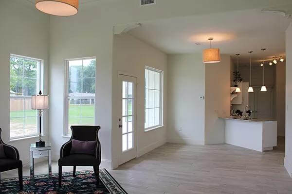 An open layout view of the living room, dining area, and kitchen surrounded by white walls.