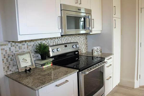 The kitchen includes stainless steel appliances and granite counters.