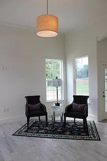 Living room with modern chairs over the bordered area rug.