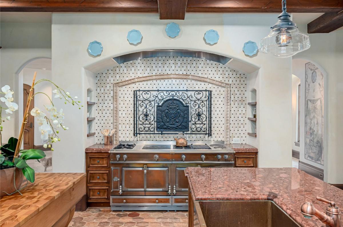 Kitchen with a Renalto wood burning pizza oven, La Cornue range and reclaimed terra cotta flooring.