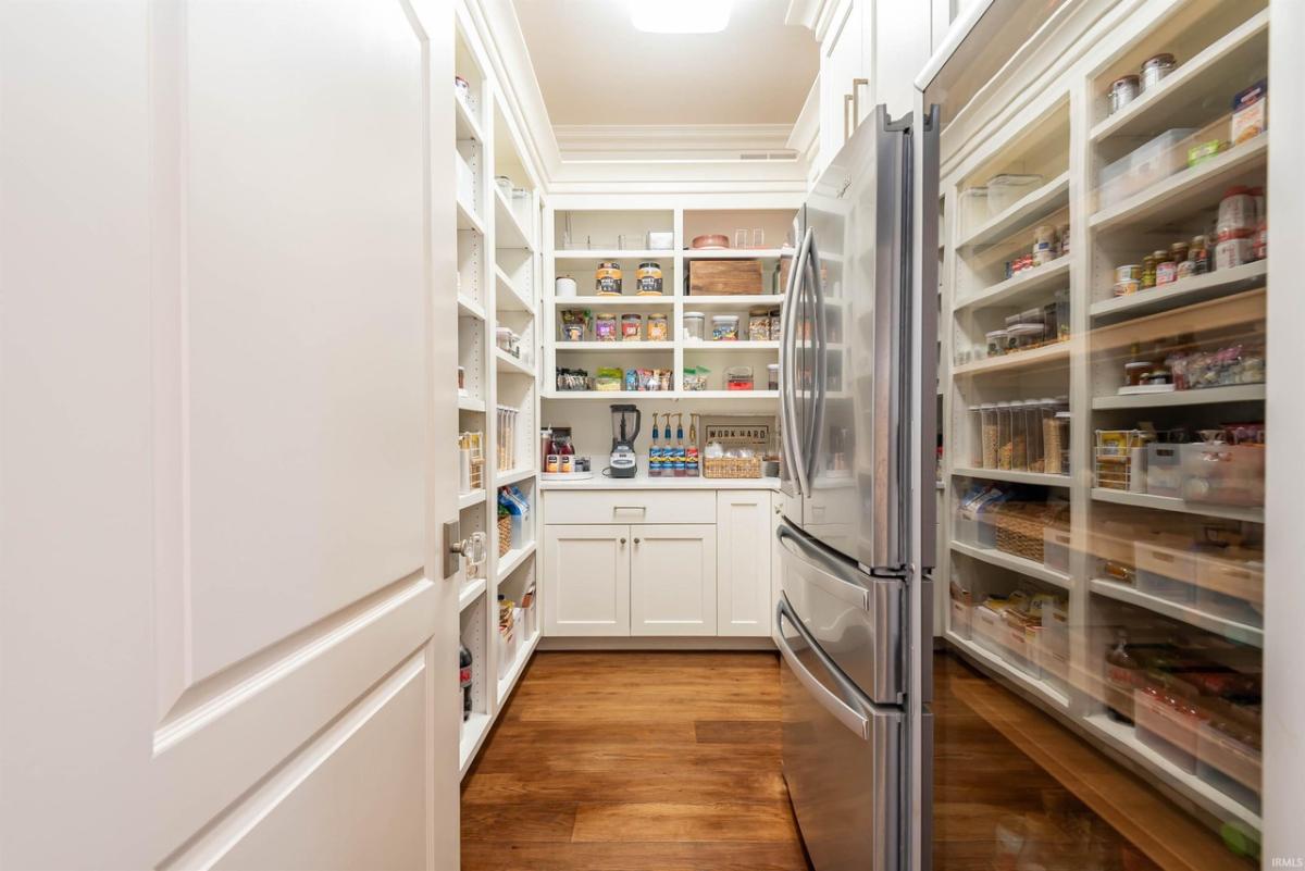 Pantry with a fridge and shelves.