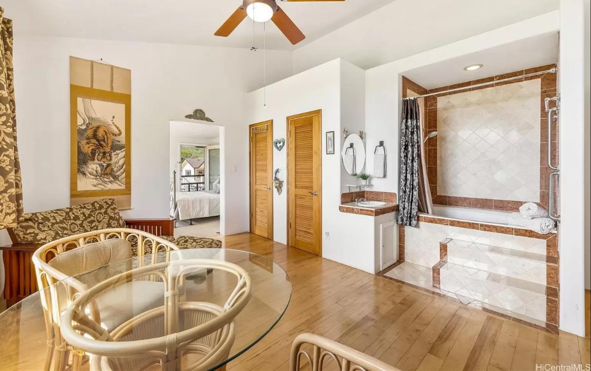 Bathroom with a soaking tub, a glass table and chairs.