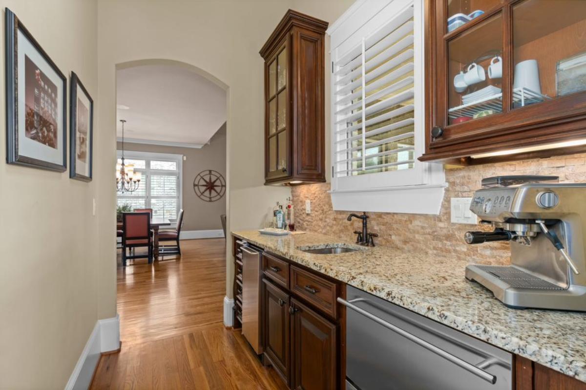 A narrow kitchen with a sink, countertop, and cabinets.