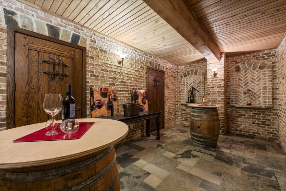 A wine cellar with brick walls and a barrel used as a table.