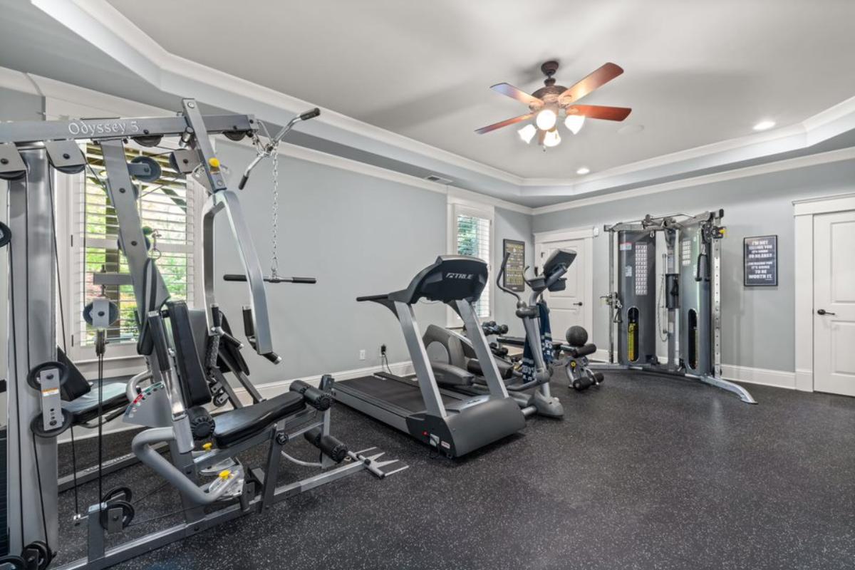A home gym with a ceiling fan and gym equipment.