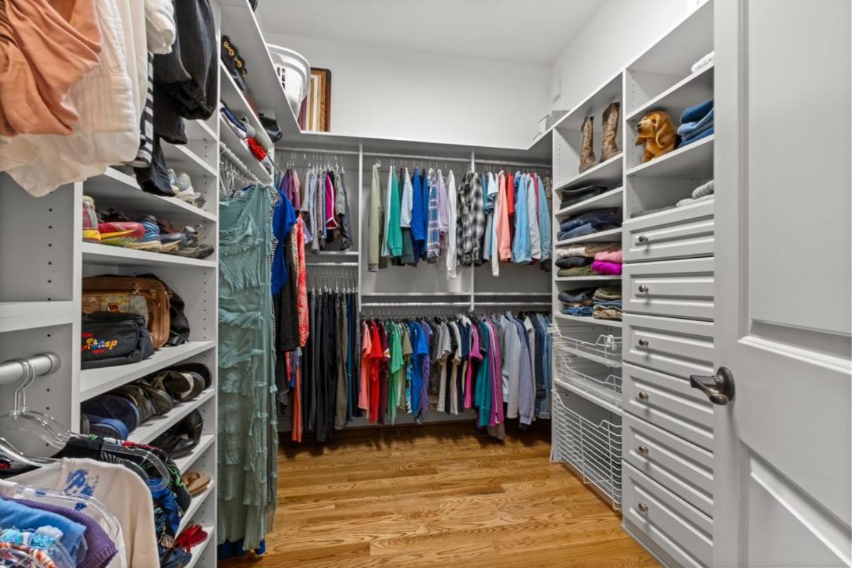 A walk-in closet with cabinets and drawers.