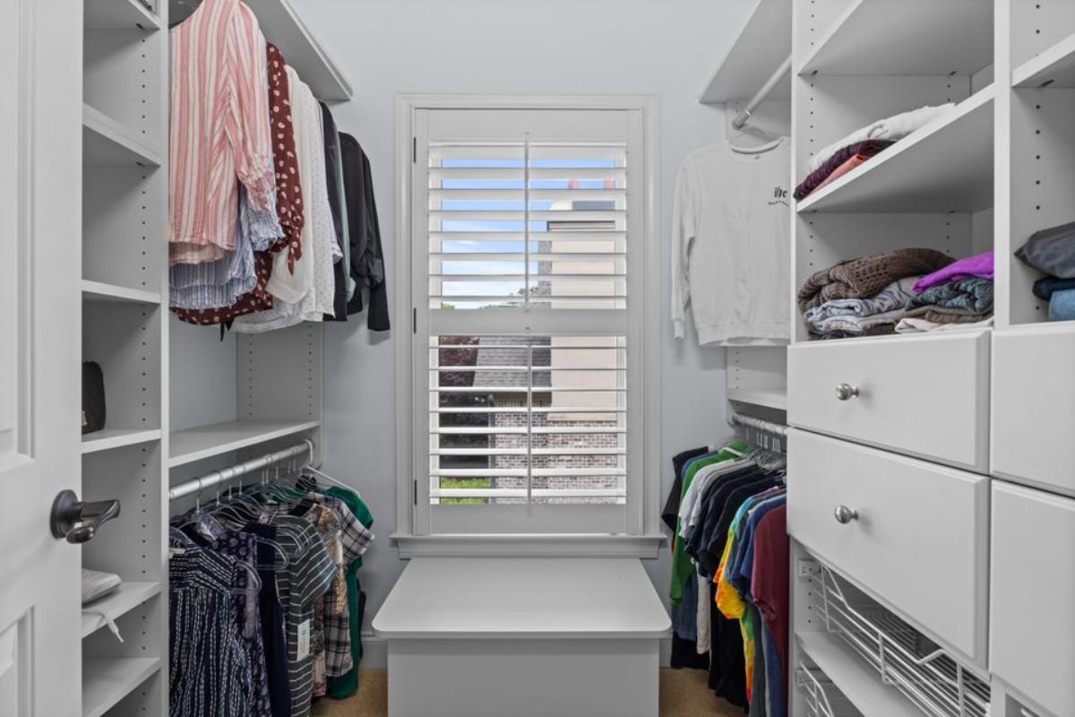 A walk-in closet with cabinets and drawers.