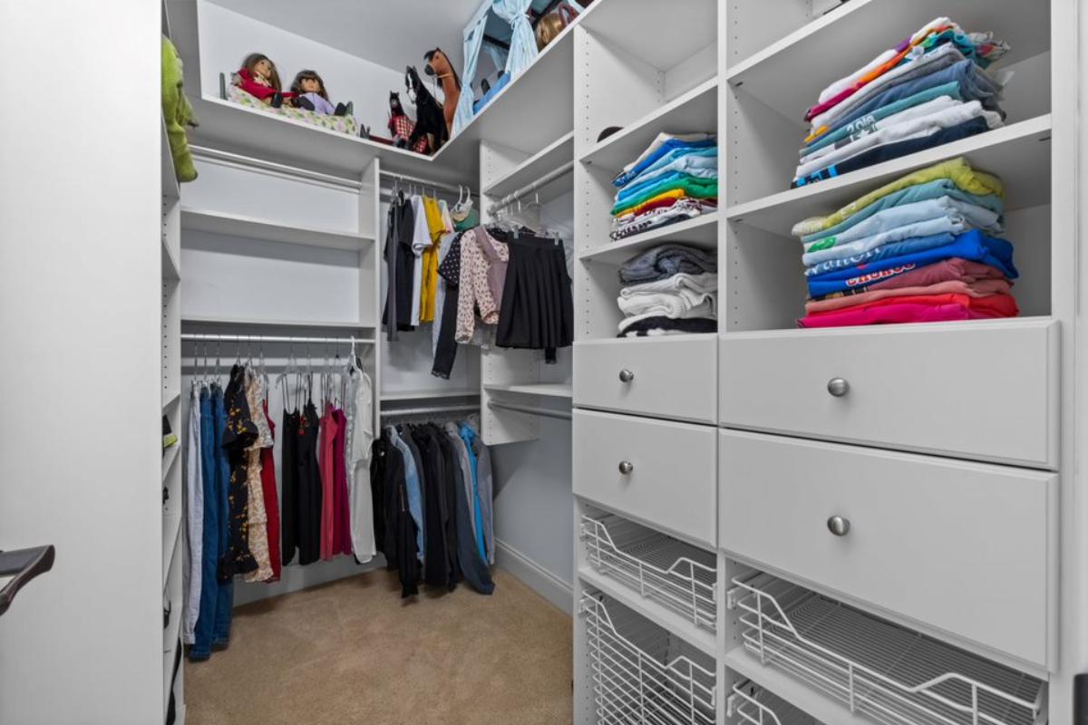 A walk-in closet with cabinets and drawers.