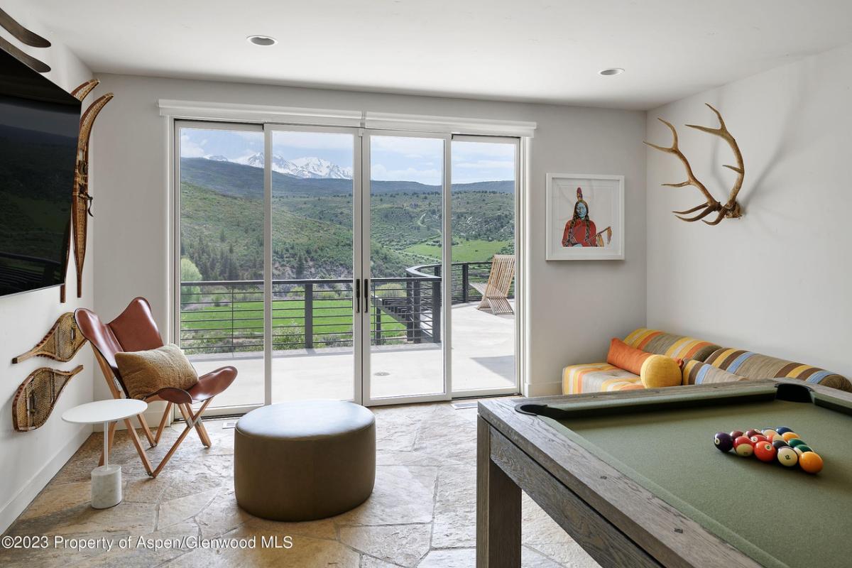 Billiards room with flagstone flooring and sliding glass door.