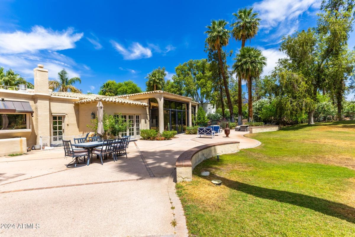Backyard of the mansion with a large green lawn.