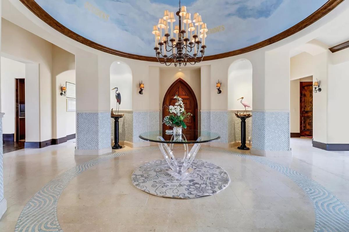 Foyer with tile flooring and a chandelier.