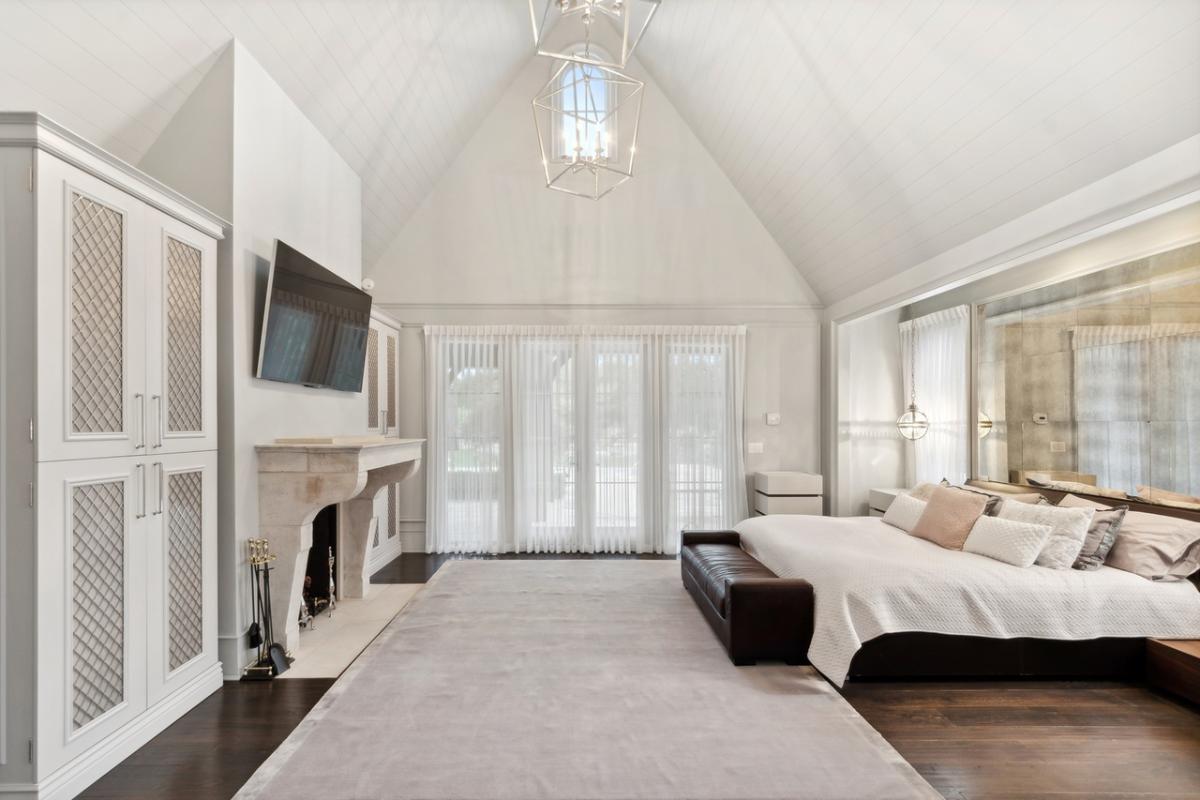 Bedroom with hardwood floors and a fireplace.