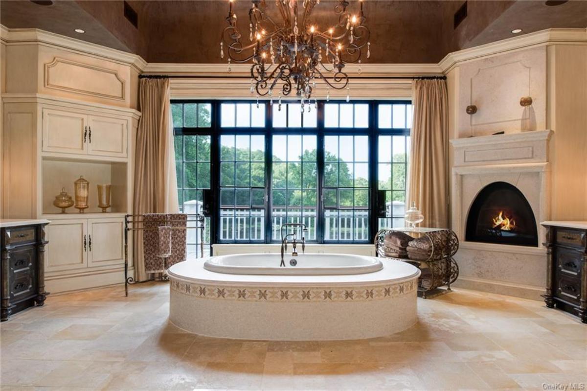 Bathroom with a soaking tub, chandelier and a fireplace.