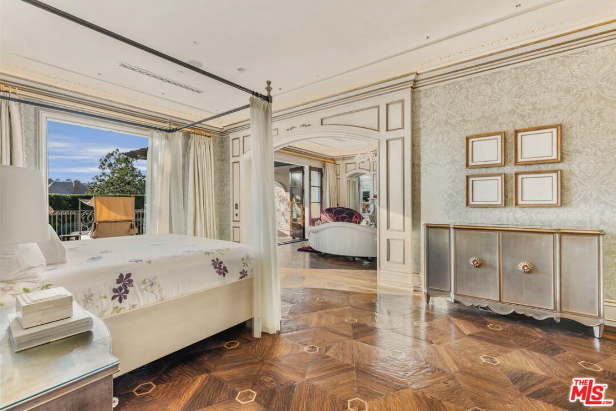 Bathroom with a large bed and hardwood flooring.