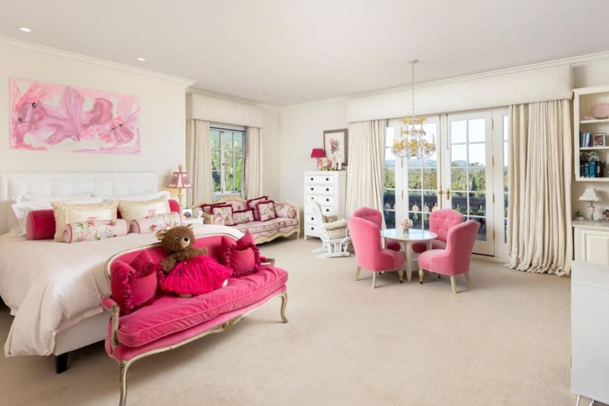A bedroom with a bed, nightstand, cabinet, shelf, couches, and a coffee table surrounded by chairs.