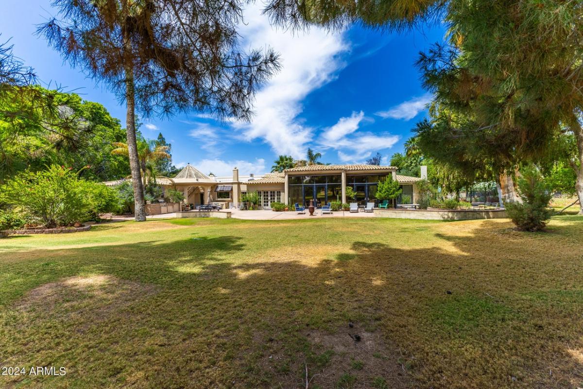 Rear view of the mansion with a large green lawn.
