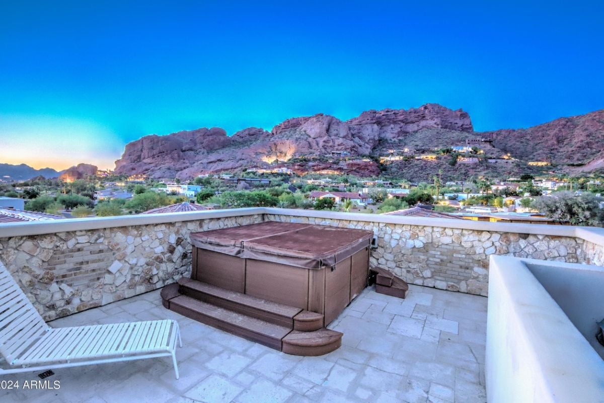 A terrace with a chair and an outdoor bathtub.