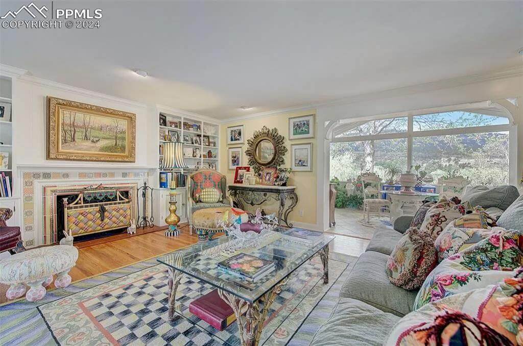 The living room includes a sectional sofa and a fireplace adorned by a landscape painting.
