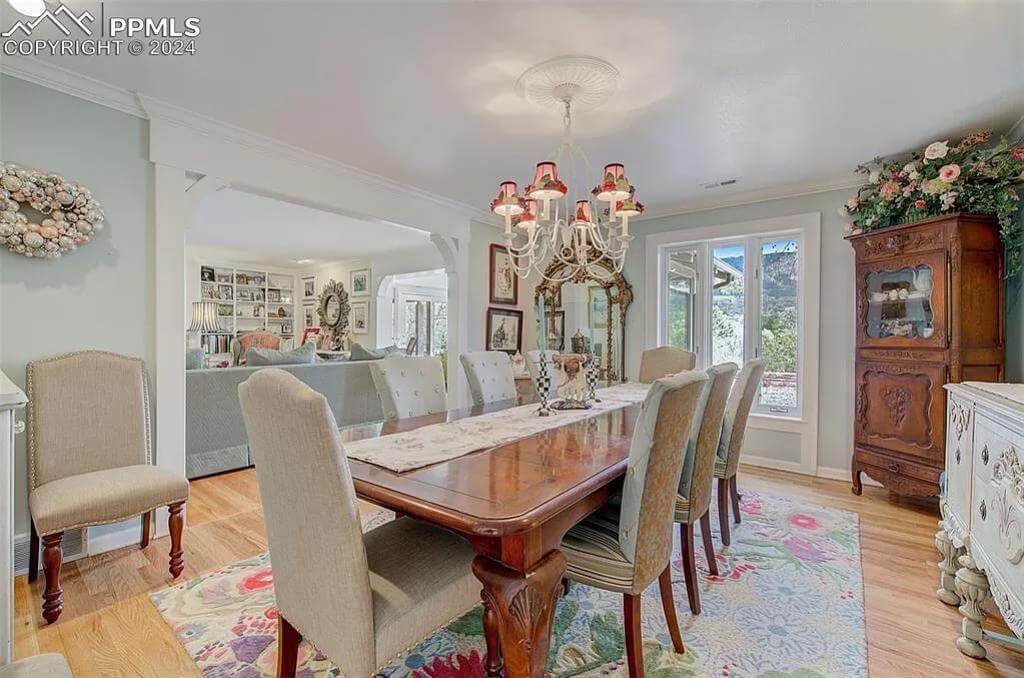 Dining room with a rectangular dining set illuminated by a traditional chandelier.