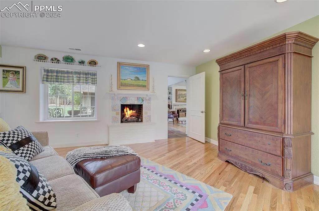 Family room with a sectional sofa, a wooden cabinet, and a fireplace.