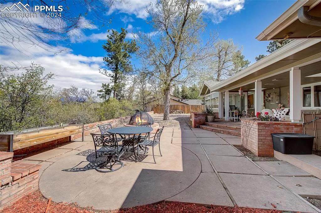 Rear patio with outdoor dining set and fire pit seating.