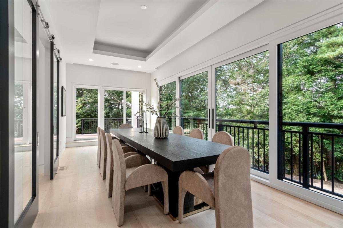 Dining room with a large wood table and sliding glass doors.