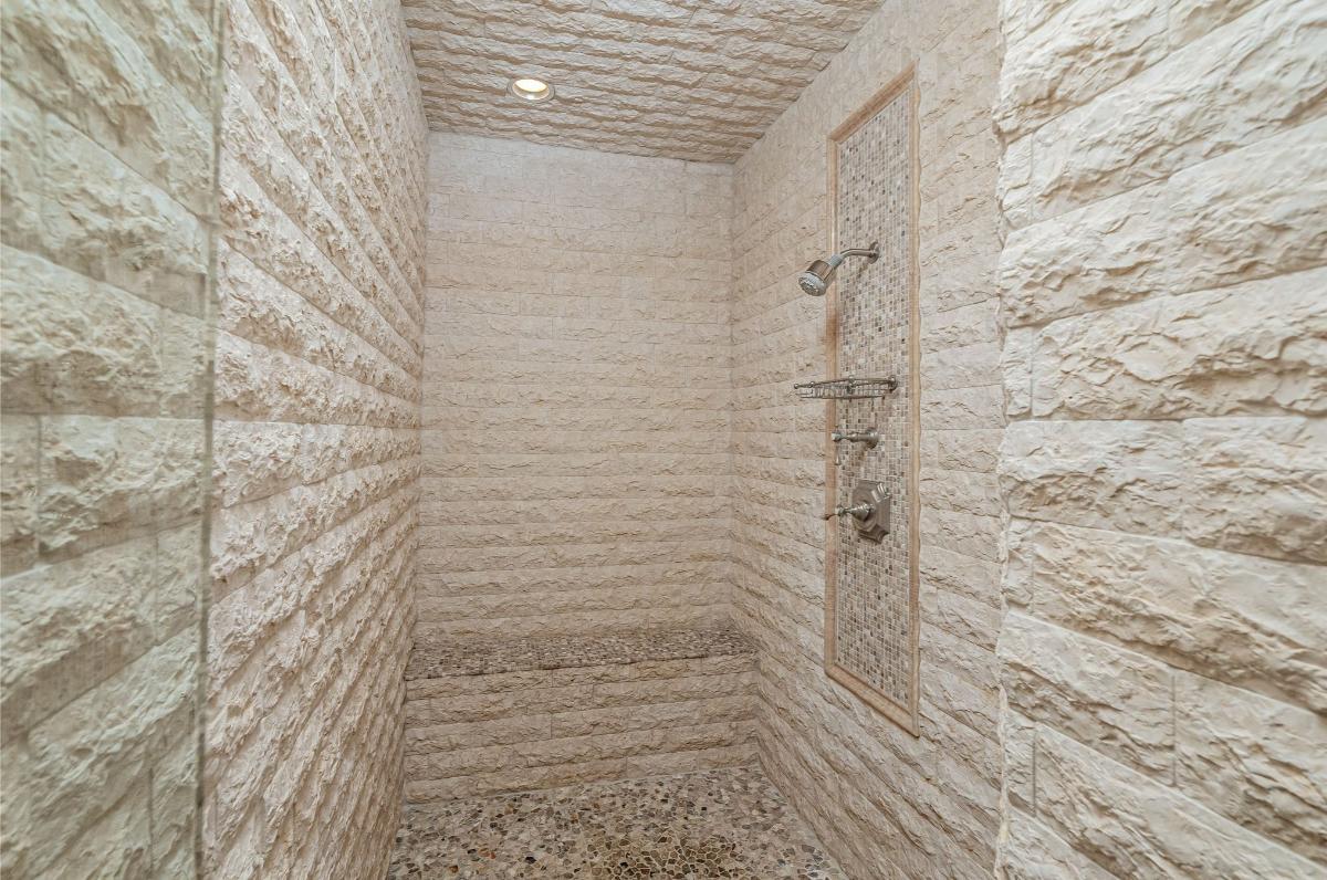 Shower room with limestone wall and ceiling.