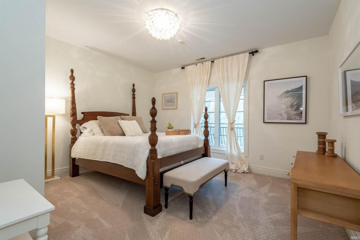 Bedroom with a large bed and carpet flooring.