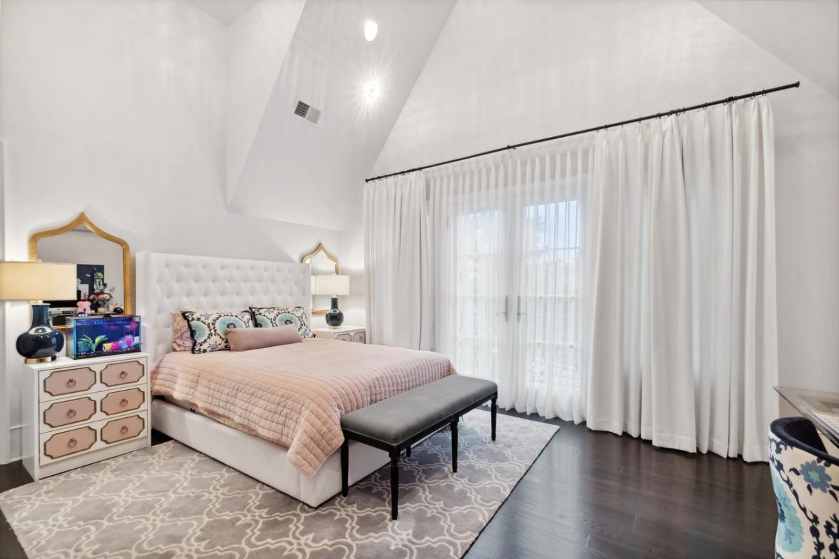 Bedroom with hardwood floor and a large bed.