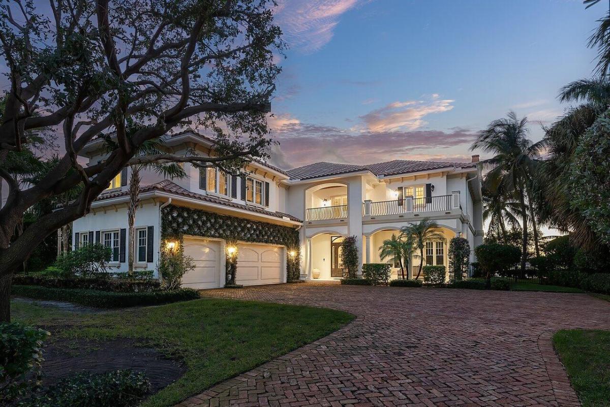 Front view of the mansion with a garage and spacious driveway.